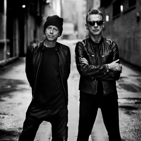 Black and white portrait of two men in leather jackets standing in an alleyway by photographer Anton Corbijn.