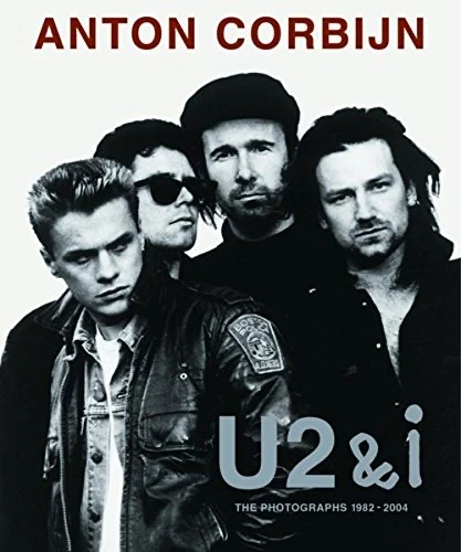 Black and white image of the rock band U2 on the cover of a book by Anton Corbijn, featuring four men in leather jackets.