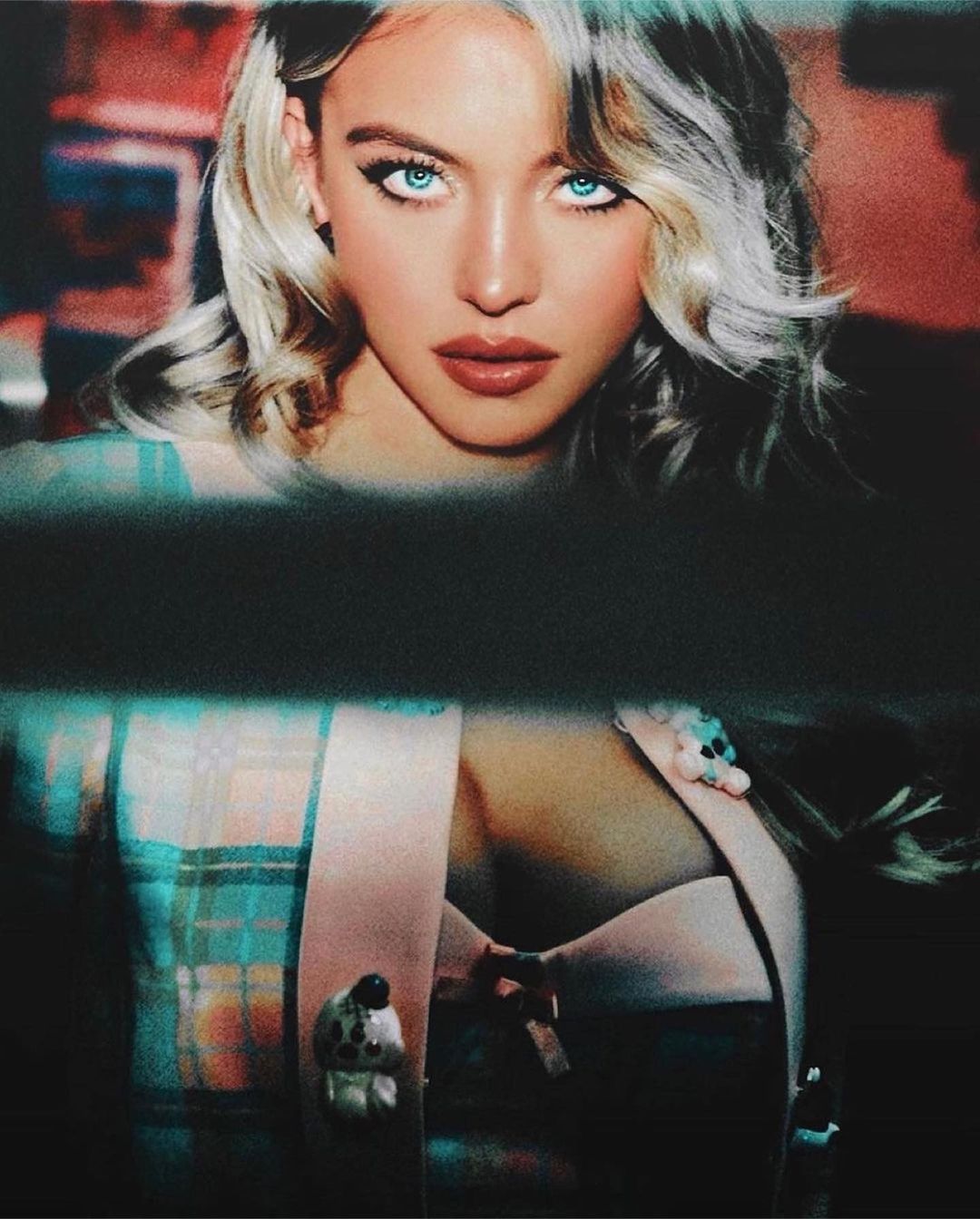 Portrait of a blonde woman wearing a plaid jacket with blue eyes and striking makeup shot by Ellen Von Unwerth.