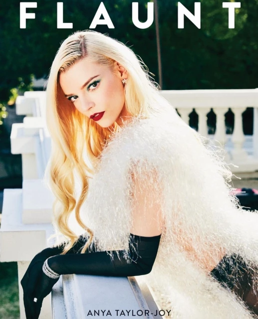 Anya Taylor-Joy poses for a magazine cover, wearing a white fuzzy top and long black gloves, with the magazine title 'Flaunt' above.