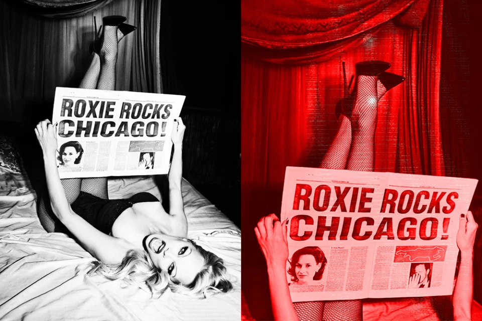 Person lying on bed, holding newspaper with headline ROXIE ROCKS CHICAGO! High-heeled shoes and fishnet stockings visible.