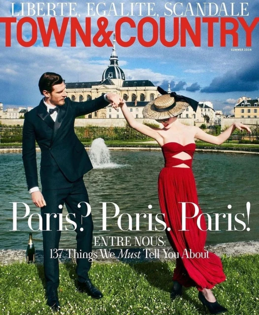 Magazine cover featuring a man in a suit and a woman in a red dress, holding hands in front of a building and a fountain in Paris.