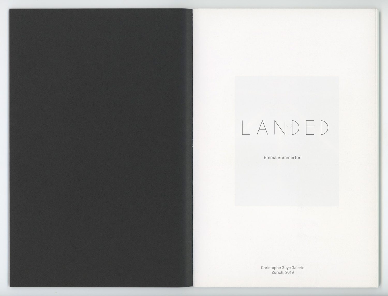 Open book displaying the title page with the word LANDED and artist name Emma Summerton