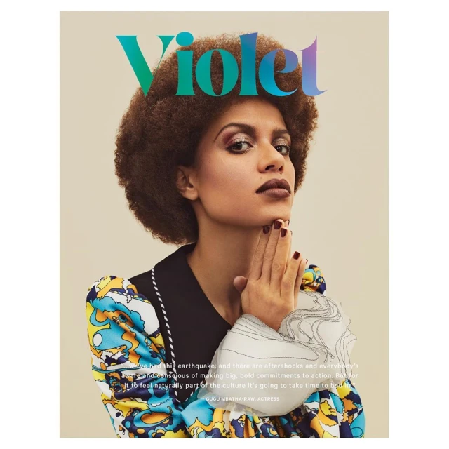 Magazine cover featuring a portrait of Gugu Mbatha-Raw, an actress, with her hands raised, wearing a colorful dress and dark lipstick.