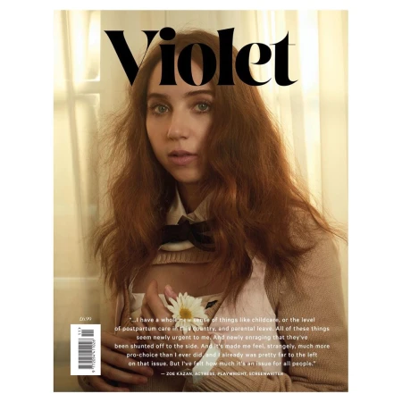 Magazine cover featuring a portrait of a young adult woman with long red hair, holding a white flower, and wearing a neutral-toned top.