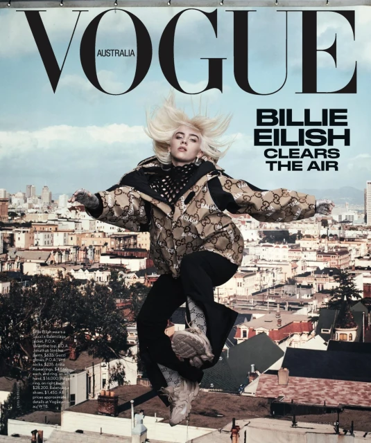 Vogue Australia cover featuring Billie Eilish mid-air, wearing a Gucci jacket, against a San Francisco cityscape under a partly cloudy sky.