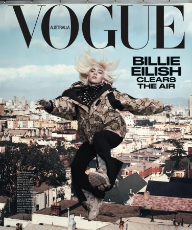 Vogue Australia cover featuring Billie Eilish mid-air, wearing a Gucci jacket, against a San Francisco cityscape under a partly cloudy sky.