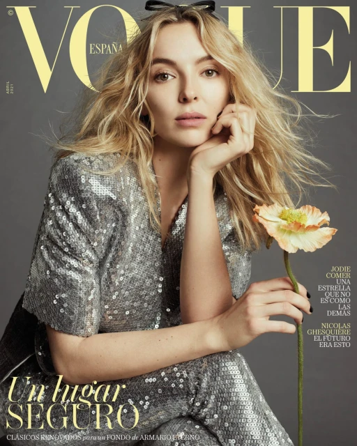 Vogue Espana magazine cover featuring Jodie Comer in a silver sequined suit, holding a flower, against a grey background with yellow text.