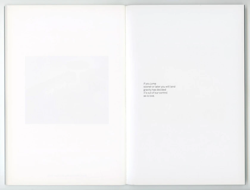 Open book with a blurred abstract image on the left page and centered minimalist text on the right page against a white background.