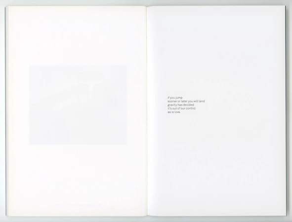 Open book with a blurred abstract image on the left page and centered minimalist text on the right page against a white background.