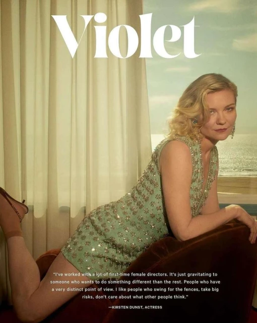Kirsten Dunst poses in a beaded dress in front of a window with an ocean view in a celebrity and entertainment editorial shot.