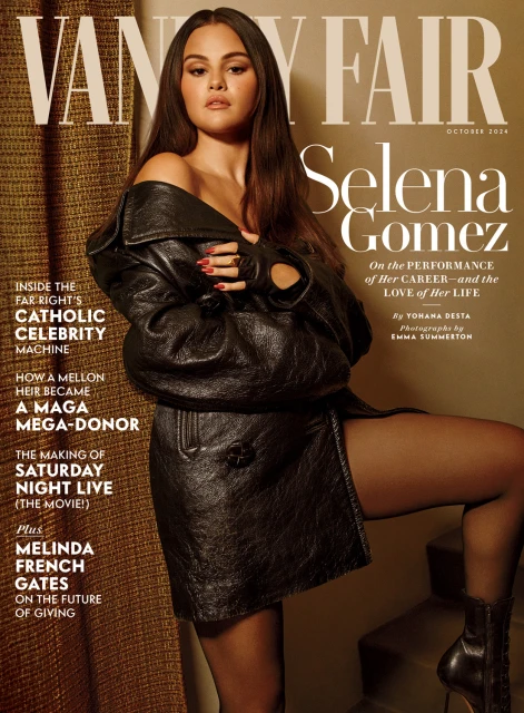 Selena Gomez on Vanity Fair cover, October 2024 issue. She poses in a black leather jacket, black tights and heels. Golden-tone background.