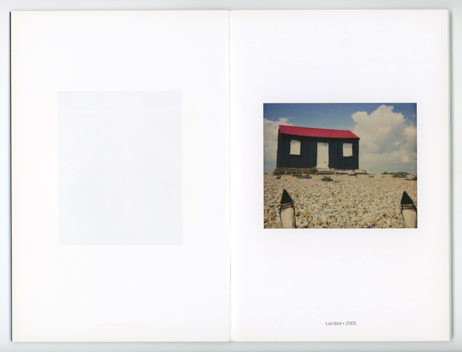 Architectural photo in a photography book shows a small building with a red roof on a rocky landscape under a cloudy sky.