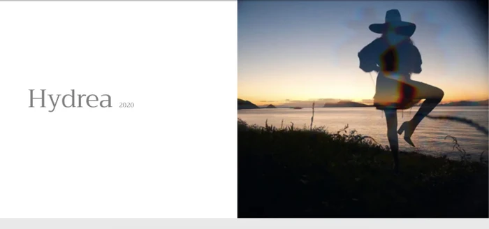 Silhouette of a person wearing a wide-brim hat posing against a coastal sunset by the ocean
