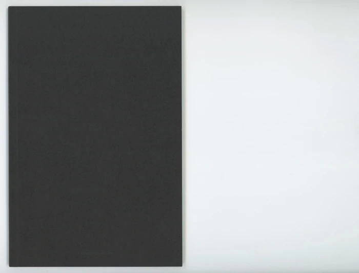 A dark grey rectangular book cover positioned against a plain light background