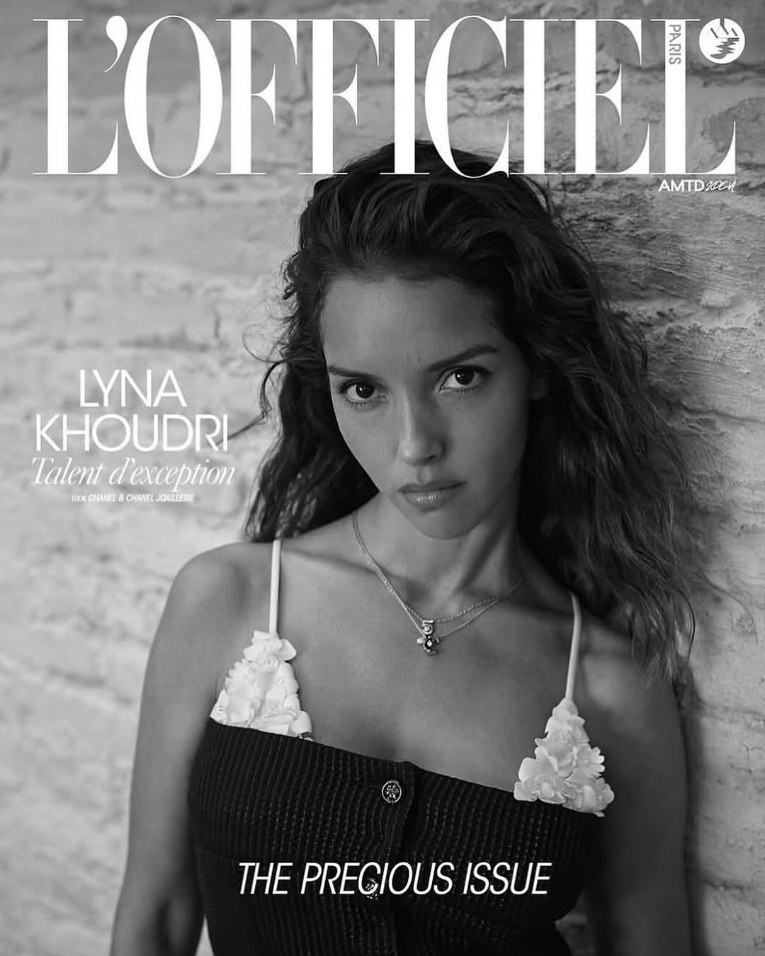 L'Officiel magazine cover featuring a portrait of Lyna Khoudri against a stone wall, showcasing black and white photography.