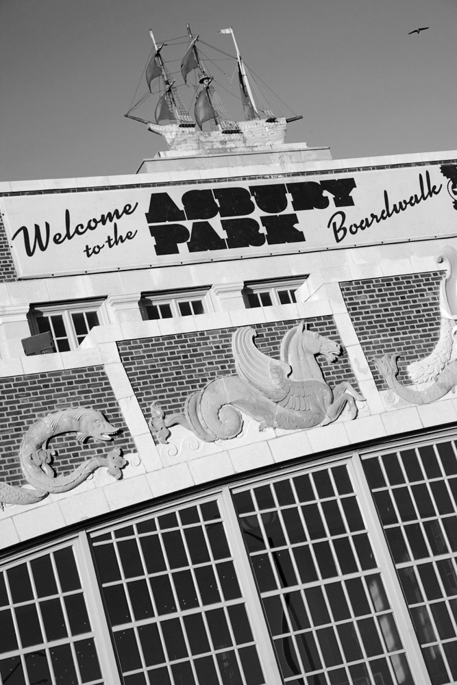 Architectural monochrome shot of the Asbury Park Boardwalk building featuring a decorative ship model and winged seahorse statues.