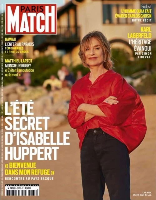 Magazine cover featuring Isabelle Huppert in a red shirt against a beach backdrop with architectural elements, and bold text overlay.