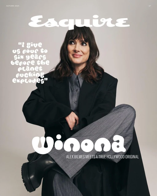 Magazine cover featuring Winona Ryder wearing a black jacket and grey striped pants, seated against a neutral background.