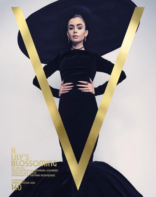 Lily Collins poses in a black dress and oversized hat with a gold "V" on a magazine cover against a light background. 