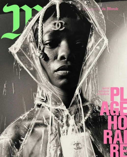 Monochrome portrait of an adult female wearing a transparent hooded raincoat with designer jewelry, set against a gray background with pink text.