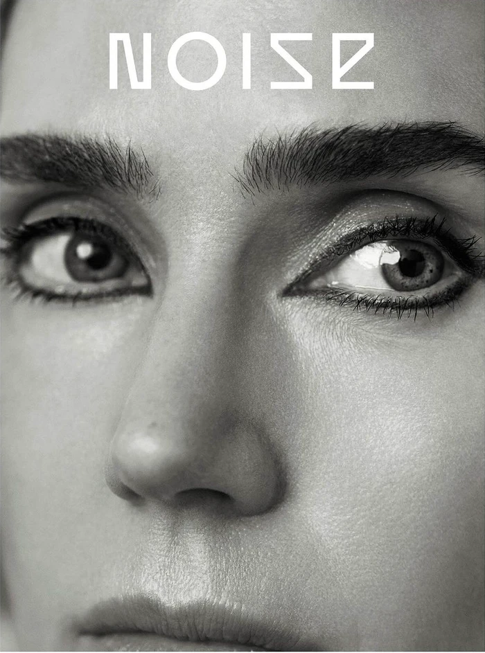 Close-up portrait of a woman face featuring bold eye makeup and defined eyebrows with the word NOISE at the top
