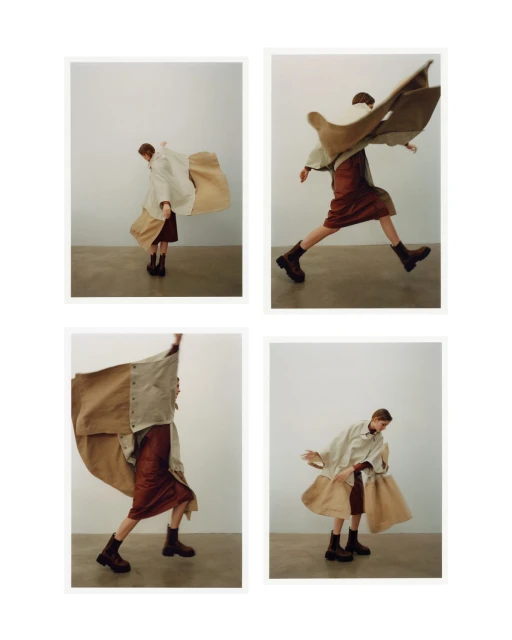 Fashion photoshoot features a person in motion wearing a beige top, a burgundy skirt, and black boots against a neutral backdrop.