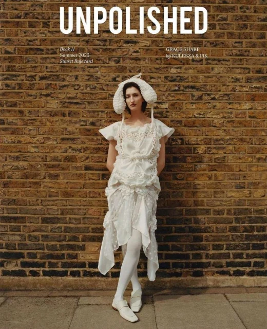 Magazine cover featuring a woman in a white dress and hat, standing against a brick wall with 'UNPOLISHED' in bold text at the top.