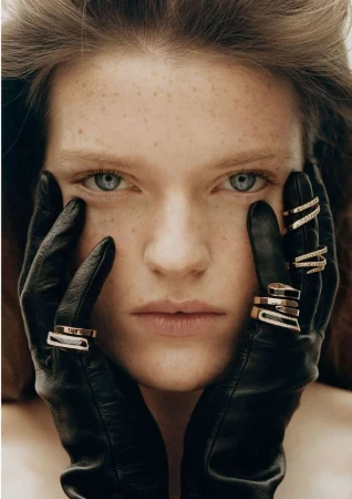 Close-up portrait of a woman with freckles wearing black leather gloves and gold rings by Kulesza and Pik