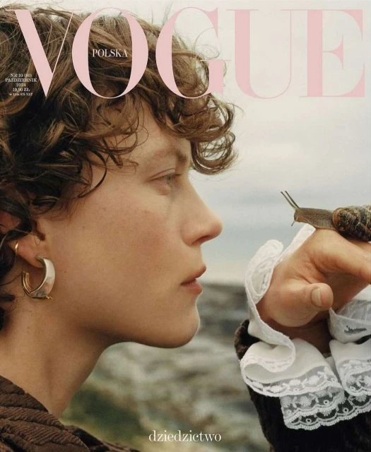 Vogue Polska cover featuring a woman in profile with soft, curly hair and gold hoop earring, gazing at a snail on her hand.