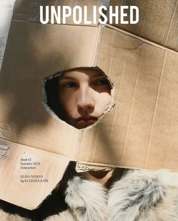 Model wearing a cardboard box over head with a jagged cutout framing face, photographed by Kulesza & Pik.