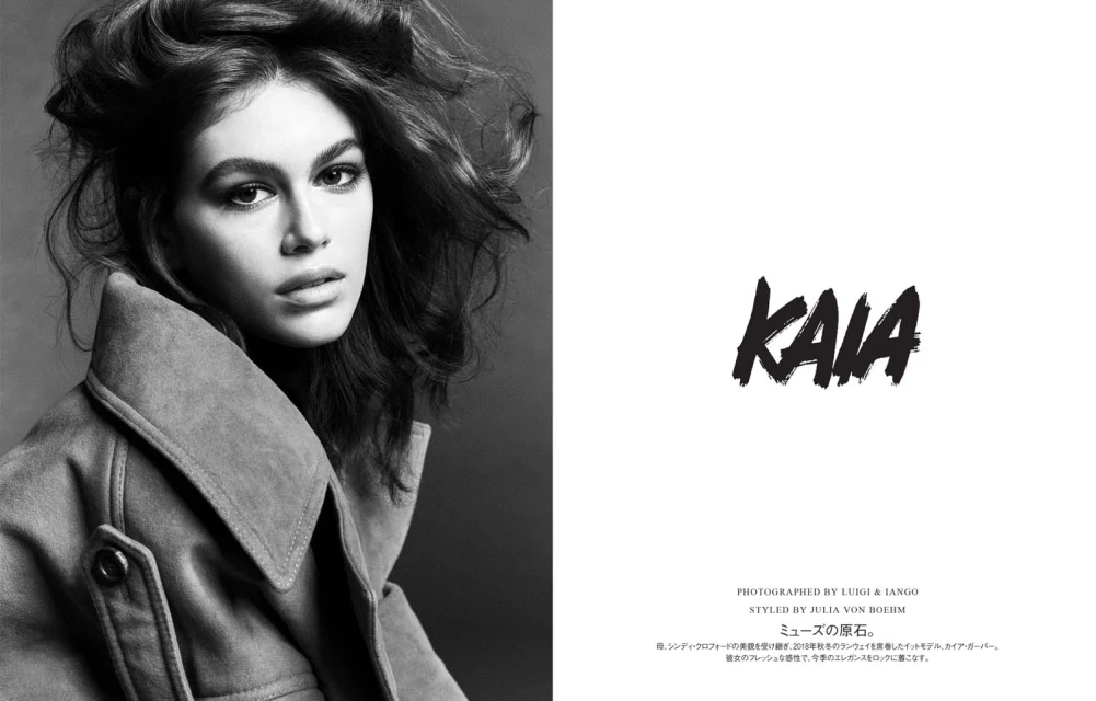 Black-and-white fashion portrait of a young adult woman with wavy hair wearing a suede jacket in a photo studio setting.