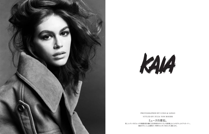 Black-and-white fashion portrait of a young adult woman with wavy hair wearing a suede jacket in a photo studio setting.