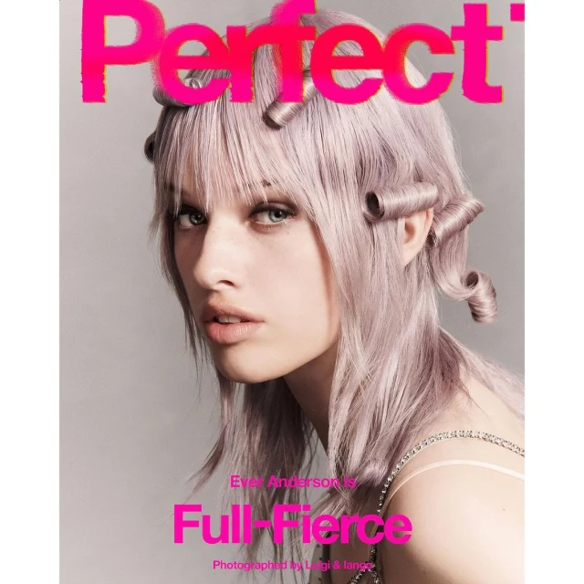 Magazine cover featuring a fair-skinned model with lavender-toned hair styled in sculpted curls posing against a neutral background.