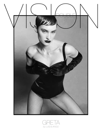 Model with dark short hair and dark lipstick wearing a black bodysuit and long satin gloves against a grey backdrop