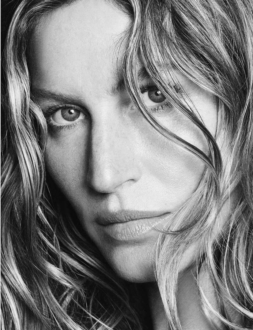Close-up black and white portrait of a woman with long wavy hair framing her face by photographers Luigi and Iango.