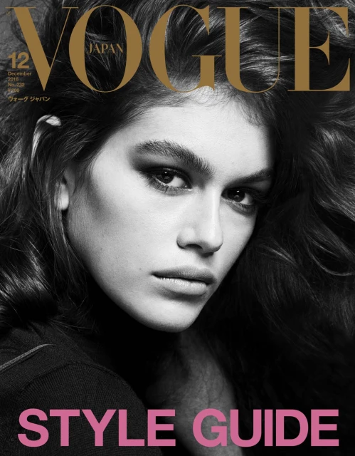 Vogue Japan cover featuring a portrait of a young woman with dark hair and smokey eye makeup on a black background with gold and pink text.