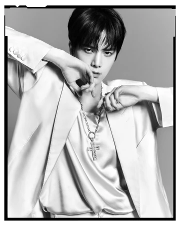 Black and white portrait of a man in a light suit and large cross necklace photographed by Luigi and Iango