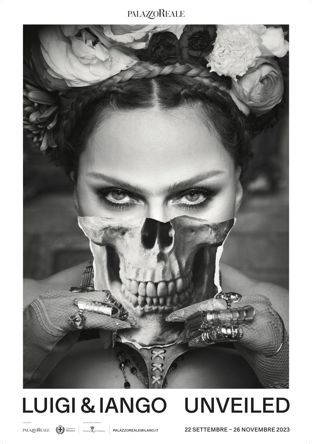 Black and white portrait of a woman wearing a floral headpiece, with a skull overlay, jewellery, and dark eye makeup in a studio.