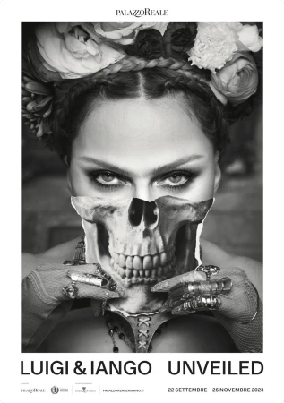 Black and white portrait of a woman wearing a floral headpiece, with a skull overlay, jewellery, and dark eye makeup in a studio.