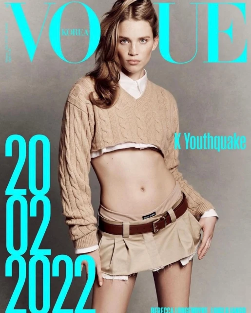 Vogue Korea magazine cover featuring a fair-skinned model wearing a cropped sweater and mini skirt, shot against a gray backdrop.