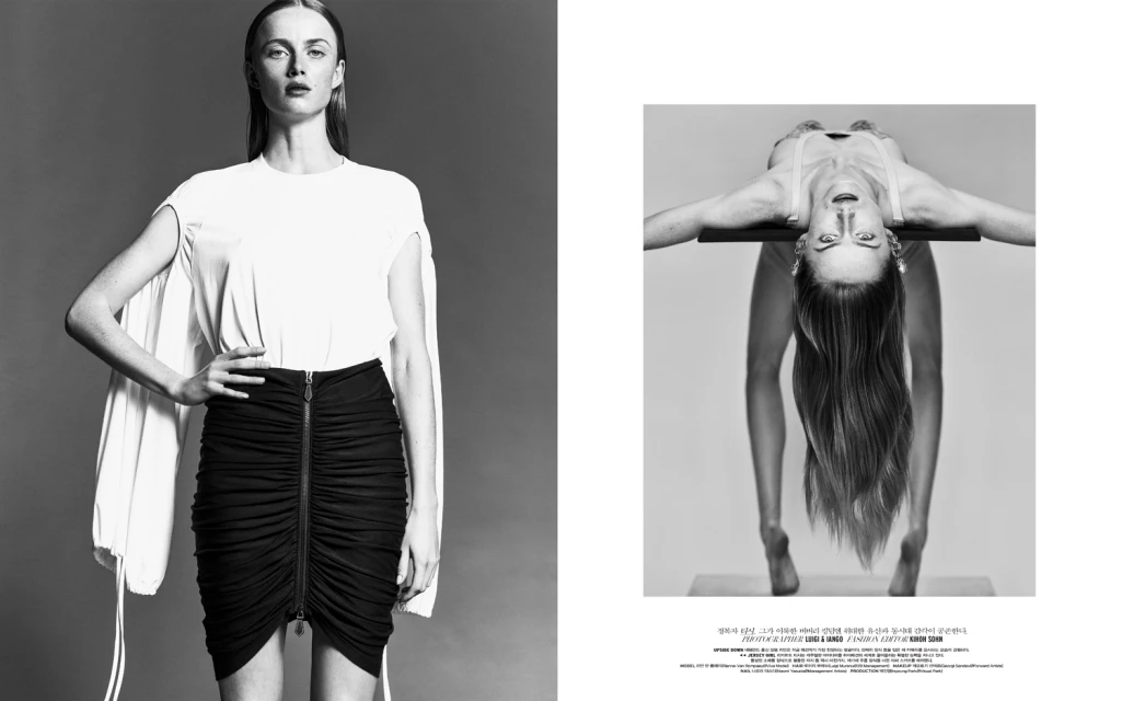 Black-and-white fashion shot of a slender woman in a stylish white top and ruched black skirt, and another woman inverted on support.