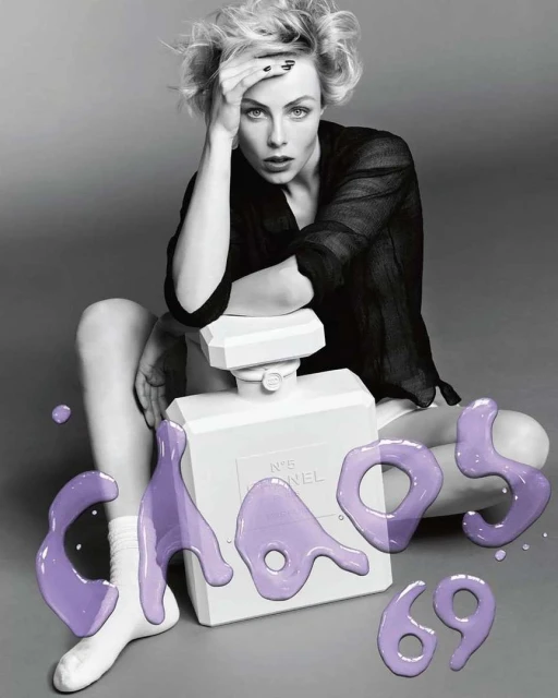 Black and white portrait of a blonde woman sitting cross-legged next to a large perfume bottle, with purple text overlay on a grey background.