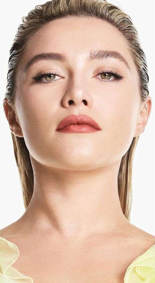 Close-up portrait of a blonde adult woman with fair skin and minimal makeup in a photo studio with soft lighting.