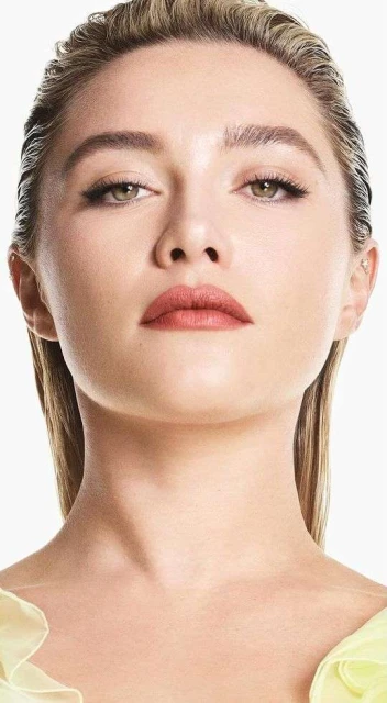 Close-up portrait of a blonde adult woman with fair skin and minimal makeup in a photo studio with soft lighting.