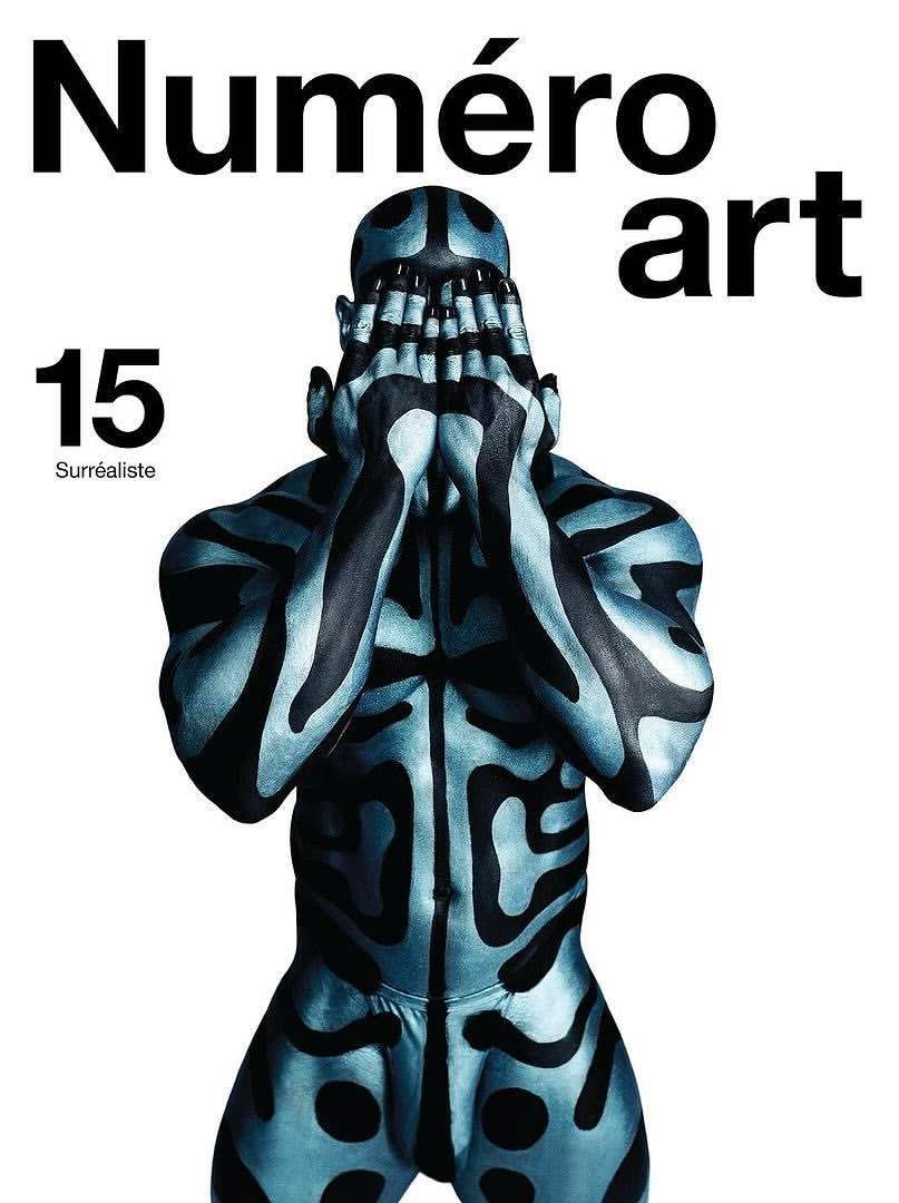 Artistic magazine cover featuring a body-painted person hiding their face, with the magazine title 'Numéro art' prominently displayed.