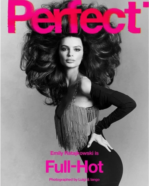 Emily Ratajkowski poses on a magazine cover with large, dark curly hair, wearing a black dress and a silver, fringed top.