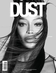 Close up monochrome portrait of Naomi Campbell with wind blown hair wearing a feathered headpiece for Dust magazine cover