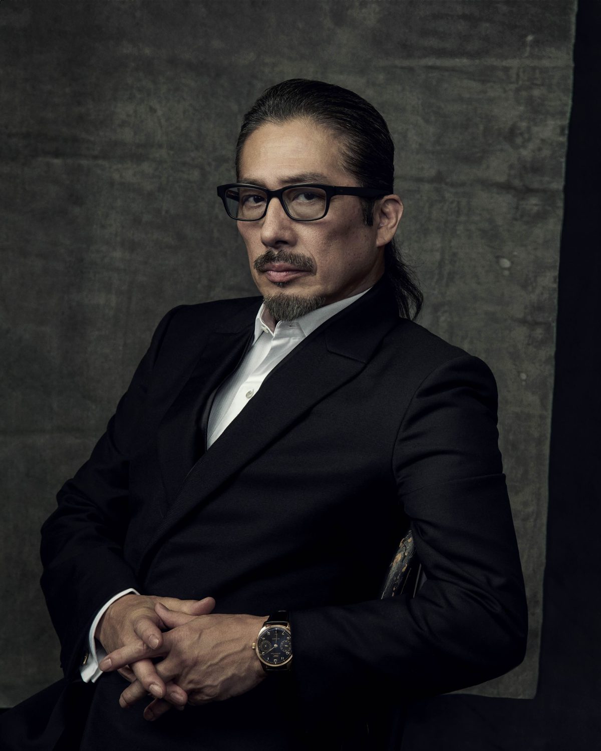 Portrait of Hiroyuki Sanada wearing glasses and black suit jacket directed by Matthew Brookes