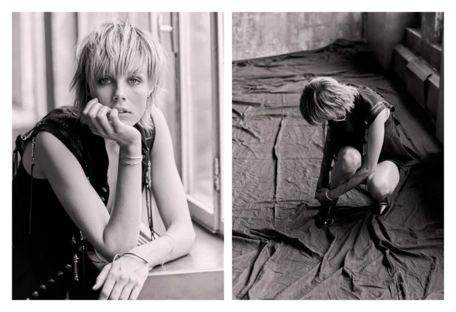 Monochrome portrait of a fair-skinned woman with short blonde hair in a sleeveless top, resting her chin on her hand by a window.